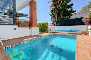 A swimming pool with a tiled edge, a brick chimney, and a covered seating area. - Villa in Puerto Marina with private and heated pool (Benalmádena)