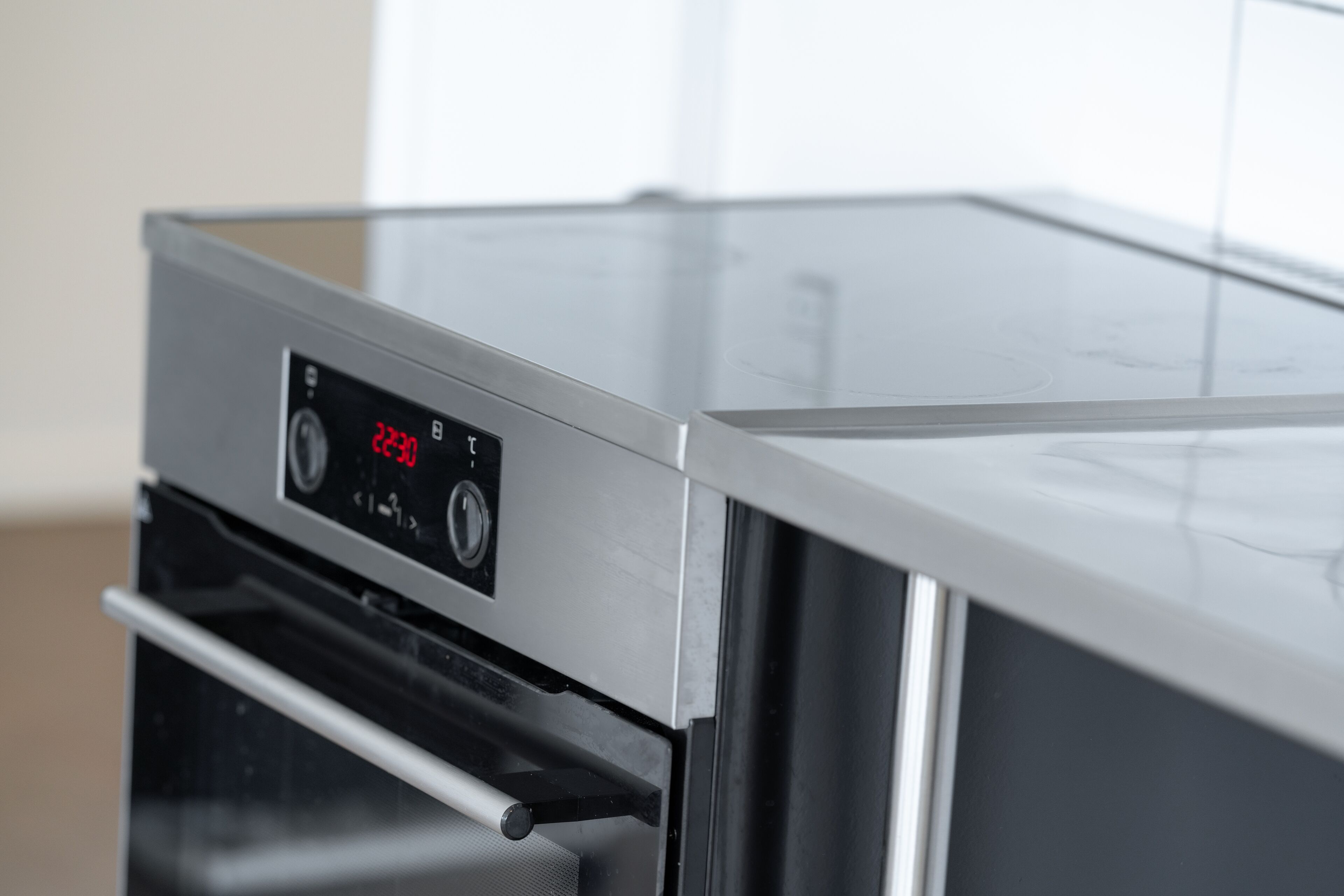 A stainless steel oven with a digital display showing 23:30.
