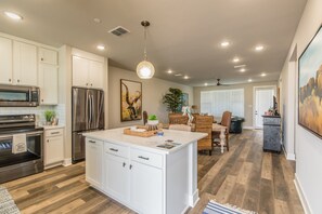 A modern kitchen with white cabinets, stainless steel appliances, and a central island.