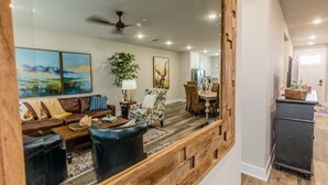 Una sala de estar con un banco de madera, un sofá y un comedor con mesa y sillas.