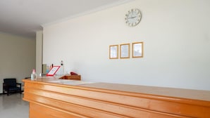A reception desk with a clock and framed pictures on the wall. - Reddoorz @ Jalan Wonosari Km.9 (Yogyakarta)