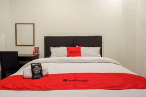 A hotel room with a bed, a desk, and a chair. - Reddoorz @ Jalan Wonosari Km.9 (Yogyakarta)