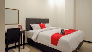 A hotel room with a bed, a desk, and a chair. - Reddoorz @ Jalan Wonosari Km.9 (Yogyakarta)