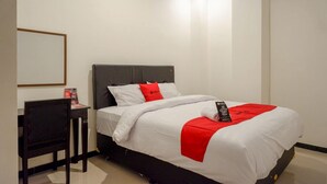 A hotel room with a bed, a desk, and a chair. - Reddoorz @ Jalan Wonosari Km.9 (Yogyakarta)