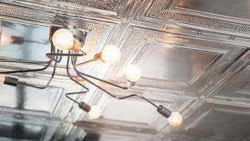 A ceiling with a geometric pattern and multiple light fixtures.