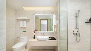 Une salle de bain moderne avec une douche à parois de verre, un lavabo blanc et des toilettes.