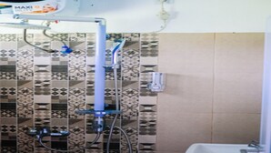 Ein Badezimmer mit gemusterten Fliesen, einer Duschbrause und einem Waschbecken.