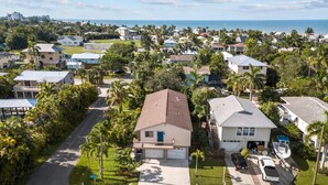 Un quartier résidentiel avec des maisons, une route et une vue sur l’océan.
