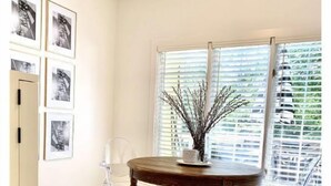 A dining area with a round table, chairs, a cabinet, and framed pictures on the wall. - Beautiful, historic home - Private (Birmingham)