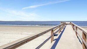 A wooden boardwalk leading to a beach with a clear sky. - Unwind by the Beach - Savannah/Tybee (Tybee Island)