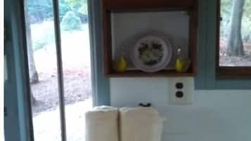 Una habitación con un cartel que dice 'hello', una cesta con toallas y vistas por una puerta.