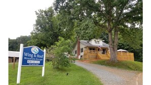 A sign for Wing & Hoof Mountain Escape with a contact number and address.