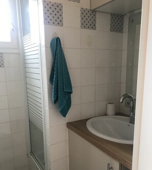 Chuveiro, secador de cabelo, toalhas de banho, sabonete