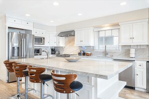 The kitchen comes stocked with dishes, pots/pan, eating and cooking utensils, cookware, bakeware, and large and small appliances.
                
