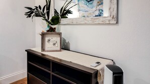 A reception area with a framed welcome sign, a potted plant, a framed picture, and a large mirror on the wall. - Cozy Apartment Minutes from Downtown (Rapid City)