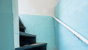 A set of stairs with a handrail, painted in a light blue color, leading to an upper level. - Cozy Apartment Minutes from Downtown (Rapid City)