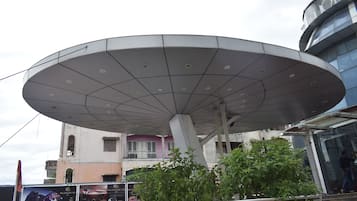 A large, modern satellite dish structure with a central support pillar and multiple smaller supports.