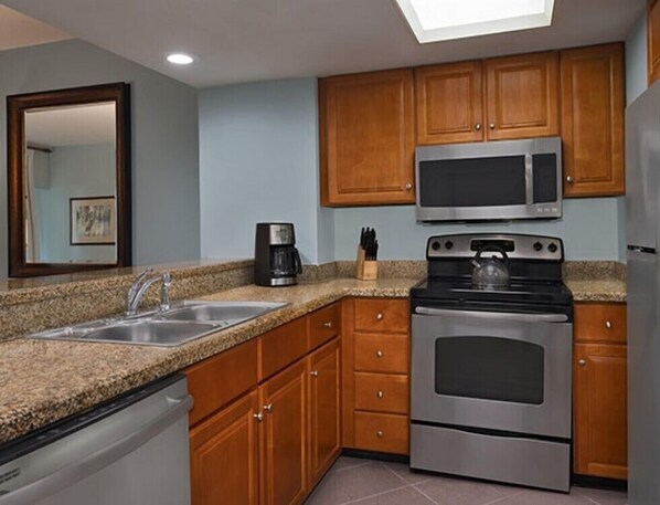 Enjoy cooking in this well-equipped kitchen with a stainless steel oven, dishwasher, and ample countertop space.