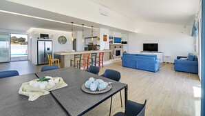 Een moderne woonruimte met keuken, eethoek en zithoek.