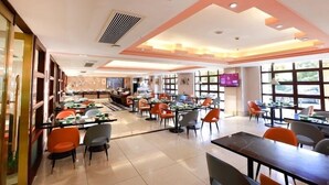 A restaurant with multiple dining areas, tables, and chairs. - Nanjing Suning Universal Hotel (Nanjing)