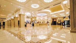 A spacious lobby with a polished floor, ornate ceiling designs, and a reception area. - Nanjing Suning Universal Hotel (Nanjing)