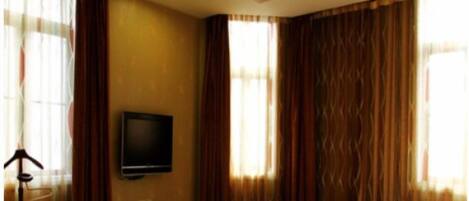 Una habitación de hotel con dos camas, un televisor y una pequeña mesa.