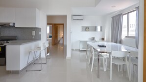 A modern kitchen with white cabinetry, a granite countertop, and a built-in stove.