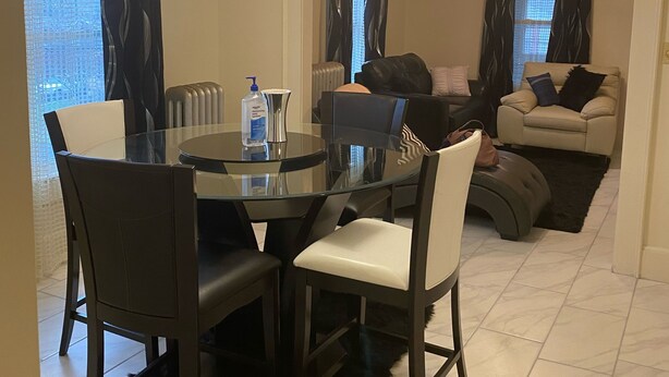 A modern living room with a glass dining table, dark chairs, a sofa, and a ceiling fan. - Two Families, up and Down Stairs, the 2nd Floor is the Vrbos Apartment (New Britain)