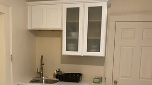 A kitchen with white cabinets, a sink, and a door. - Two Families, up and Down Stairs, the 2nd Floor is the Vrbos Apartment (New Britain)