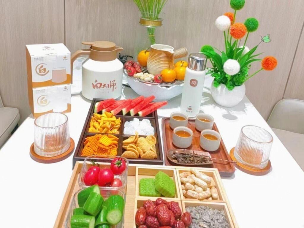 A table with various food items and drinks, including fruits, vegetables, and snacks.