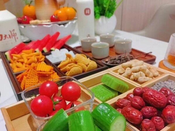 A buffet with various food items including fruits, vegetables, and snacks.