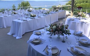 Enjoy a sophisticated dining experience with elegant table settings and breathtaking sea views.