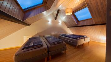 Ein Zimmer mit zwei Betten, einem Oberlicht und einer Pendelleuchte.