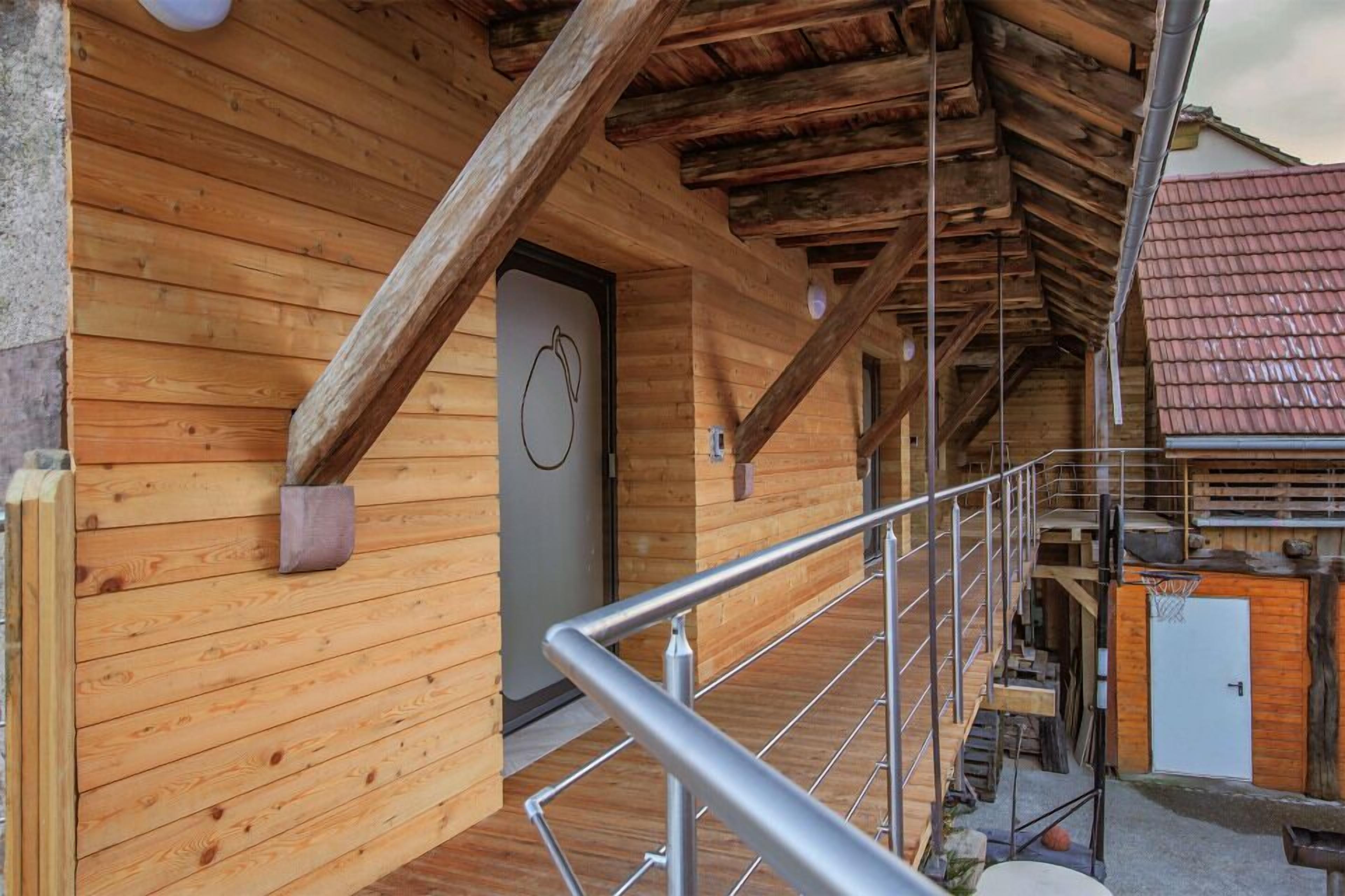 Une cabane en bois avec un escalier en métal et un panier de basket.
