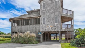 A multi-story wooden building with a balcony and a sign that reads "Blue Whale."