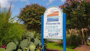Welkomstbord voor Ocean Sands North met een kustontwerp.