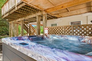 Un bain à remous avec une terrasse en bois et un espace abrité.
