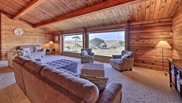 A log cabin interior with a large sofa, two armchairs, a coffee table, a lamp, and a clock on the wall. - Coastal Oregon Retreat w/ Grill: 11 Mi to Astoria! (Warrenton)