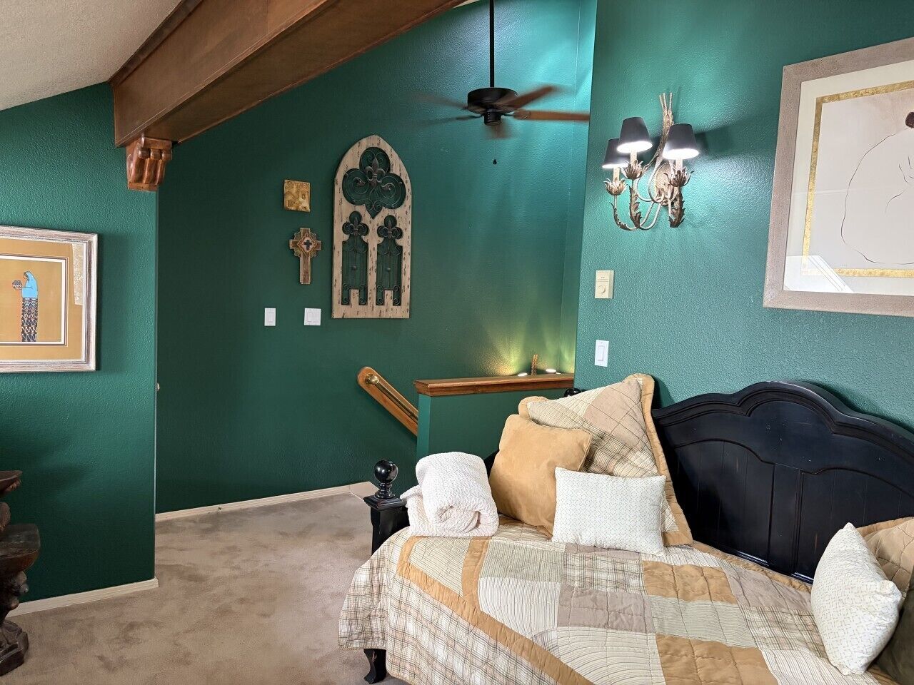 A bedroom with a bed, a ceiling fan, wall-mounted lights, and a wooden bench.