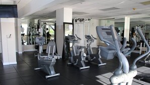 A gym with various exercise equipment including treadmills, elliptical machines, and weight machines. - Pavilion by Design Suites Miami (Miami Beach)