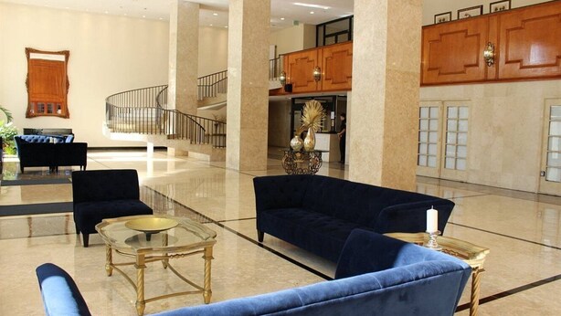 A spacious lobby with a grand staircase, a reception desk, and plush seating areas. - Pavilion by Design Suites Miami (Miami Beach)