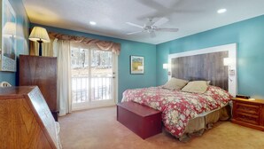 A bedroom with a bed, a desk, a chair, a ceiling fan, and a window with curtains. - Pet Friendly | Close to Lifts | Spacious | Garage Access | Angel Fire Commons C8 (Angel Fire)