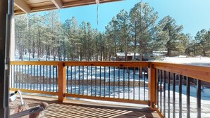 A wooden deck with a railing overlooking a snowy landscape and trees. - Pet Friendly | Close to Lifts | Spacious | Garage Access | Angel Fire Commons C8 (Angel Fire)