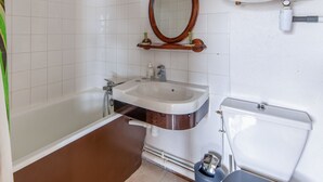 A bathroom with a bathtub, sink, and toilet. - Appartement Sémaphore - Welkeys (Cabourg)