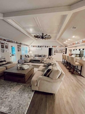 Relax in this inviting living space with a high ceiling, comfortable sofa, and dining area.