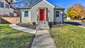 A single-story house with a red front door, a small front porch, and a concrete pathway leading to the entrance. - Cozy Home: WiFi, Parking, 5 Mi to Dtwn Mpls! (Minneapolis)