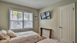 A bedroom with a bed, a TV mounted on the wall, a door, and a window with blinds. - Cozy Home: WiFi, Parking, 5 Mi to Dtwn Mpls! (Minneapolis)