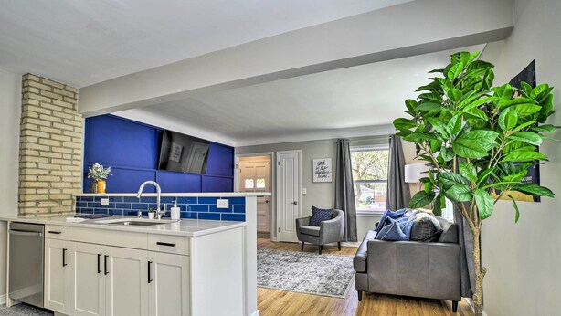 A modern kitchen with white cabinets, blue backsplash, and a brick accent wall. - Cozy Home: WiFi, Parking, 5 Mi to Dtwn Mpls! (Minneapolis)