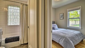A bathroom with a bathtub, a shower curtain, and a window.