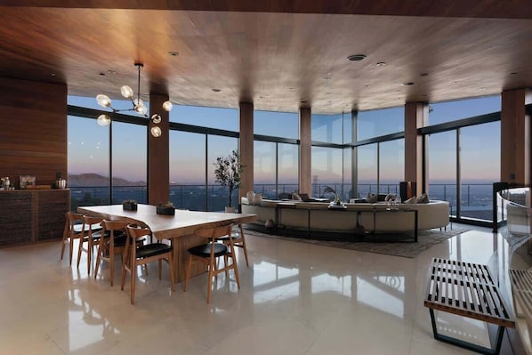A spacious room with a large dining table, seating, and a sofa.